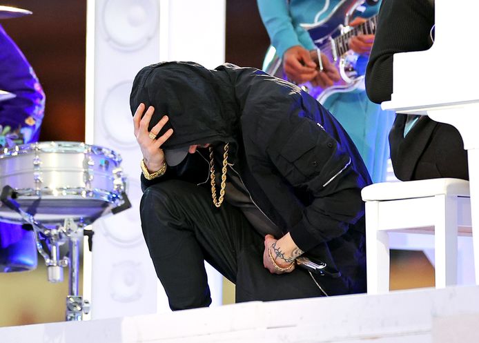 Eminem kneels at the end of his performance.