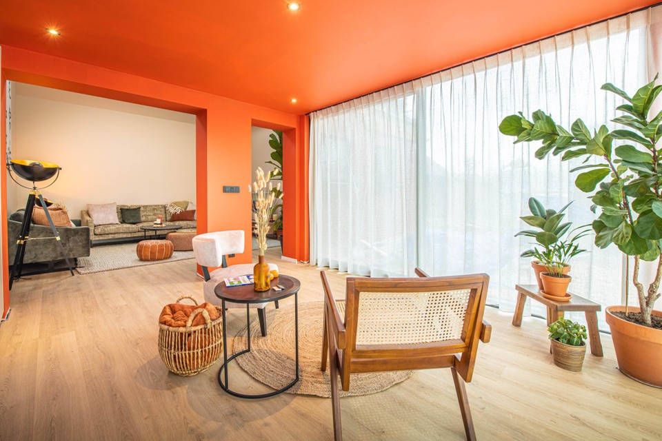 Unrecognizable living room after renovations, with much-discussed tangerine-coloured walls. 