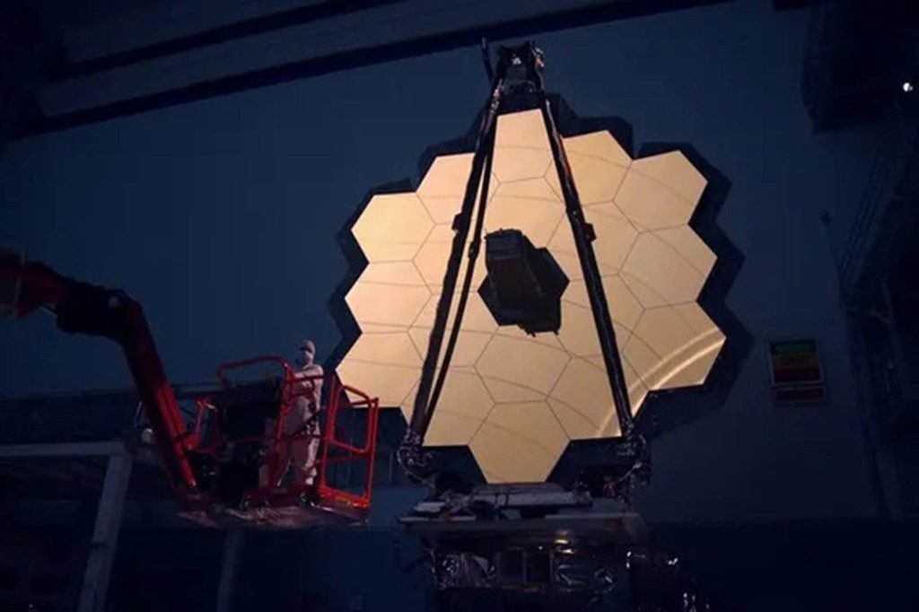 The main mirror of the James Webb Space Telescope is illuminated in the darkroom
