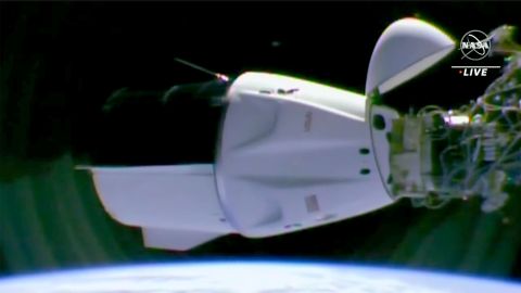 A SpaceX capsule docking at the International Space Station with international astronauts